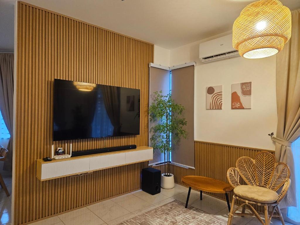 ein Wohnzimmer mit einem Flachbildfernseher an der Wand in der Unterkunft Villa Zuhaira homestay in Kangar