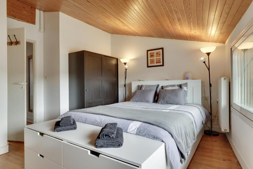 Un dormitorio con una cama grande y un techo de madera. en A Bordeaux, Climatisée avec billard, en Le Bouscat