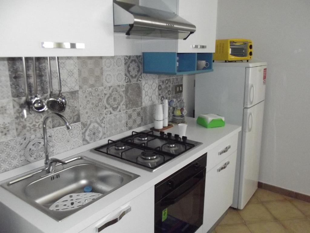 a kitchen with a sink and a stove and a refrigerator at Appartamento Vacanze Mare in Terrasini