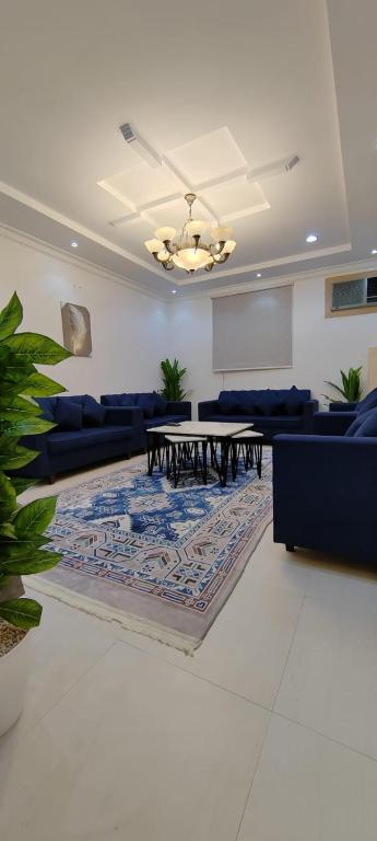 a living room with a table and blue couches at شقة عائلية مودرن 4 غرف نوم رقم 1 in Quai