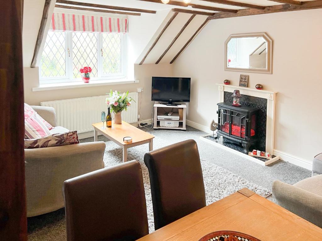 uma sala de estar com lareira e televisão em Hayloft-E2699 em Winthorpe