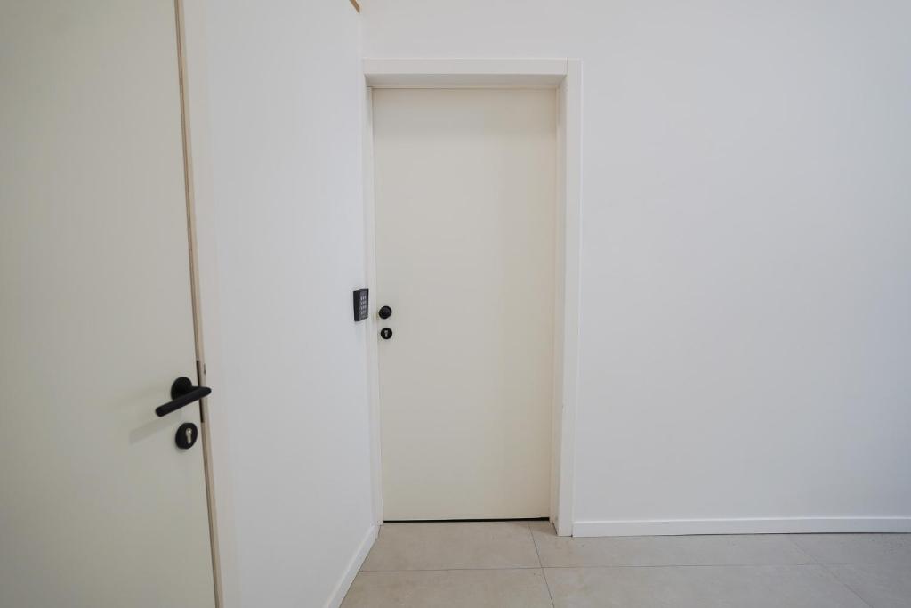 ブリュッセルにあるAppartment Vaillance 2の白い壁の部屋のドア2つ
