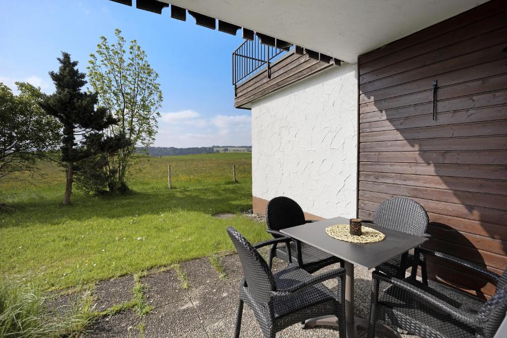 una mesa y sillas en un patio con vistas a un campo en Landliebe mit Seenähe und Innenpool, en Petersthal