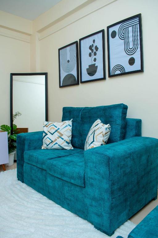 a blue couch in a living room with pictures on the wall at SJ Homes in Eldoret