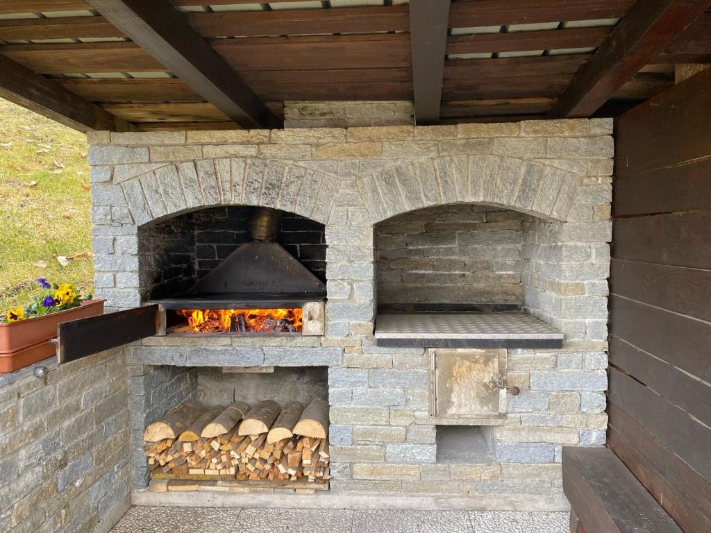 un horno de ladrillo al aire libre con chimenea en Appartamento Il Giardino, en Castello dellʼAcqua