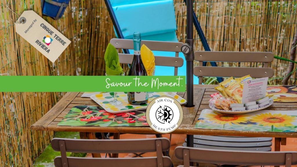 モンテロッソ・アル・マーレにあるSciacchetrà Ground Floor Apartment with ACの椅子とテーブル、そして「あなたのような夏」と書かれた看板のあるテーブル