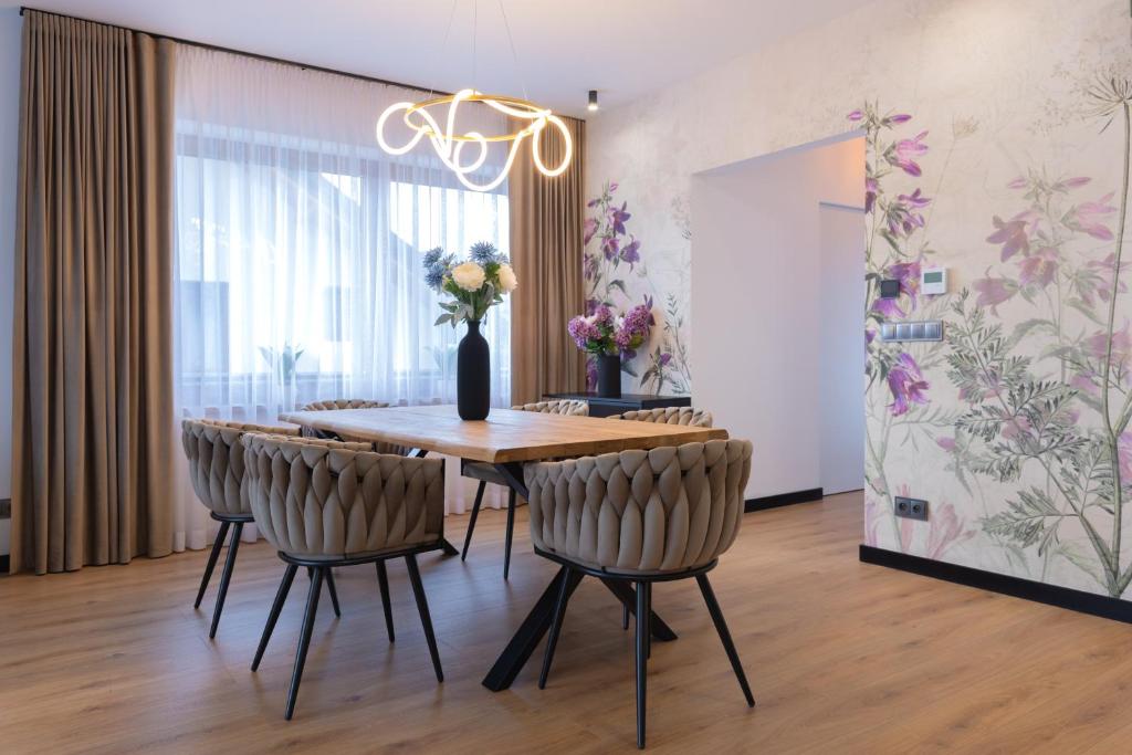 ein Esszimmer mit einem Holztisch und Stühlen in der Unterkunft Przestrony apartament z trzema sypialniami - jacuzzi i parking, kącik zabaw dla dzieci w cenie - świetny wybór dla rodzin lub grupy znajomych in Szczawnica