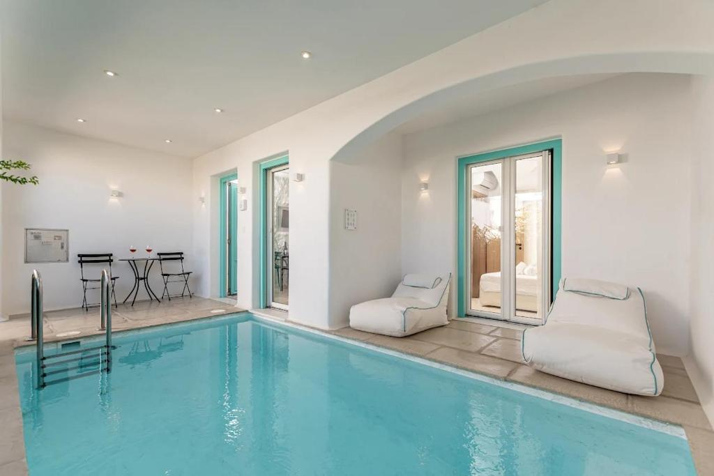 a swimming pool with two chairs in a house at Majo Suites Hotel in Agia Anna Naxos