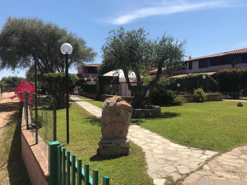 a stone statue in a yard next to a fence at San Teodoro Holiday House A in San Teodoro