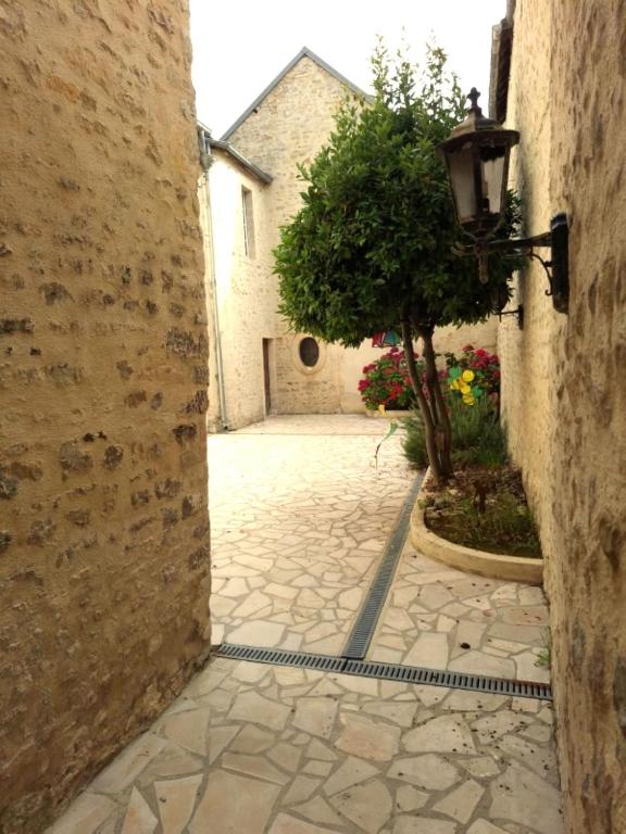an alley with a tree and a street light at Appartement Studio Le Clem's in Bayeux