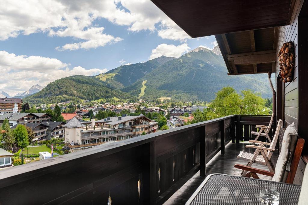 a balcony with a view of a town and mountains at Haus Excelsior Top 35 in Seefeld in Tirol