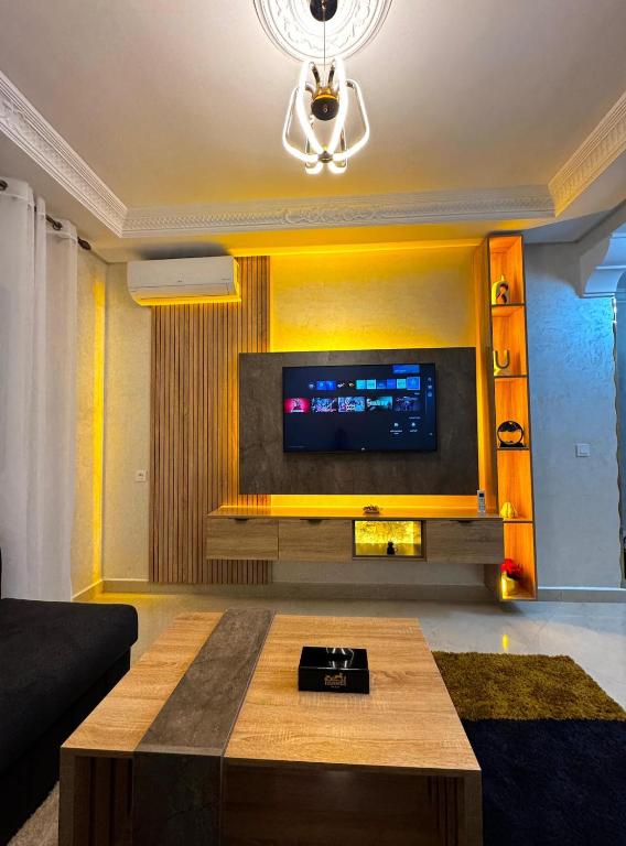 a living room with a tv and a coffee table at Appartement Tanger Stade ibn batouta in Tangier