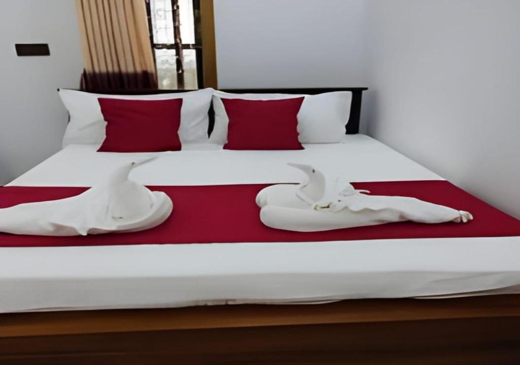 two white towels are sitting on a bed at Aadhira Guest House in Trincomalee