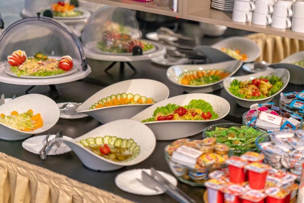 a buffet with plates of food on a table at Hotel Koncept Residence in Sarajevo