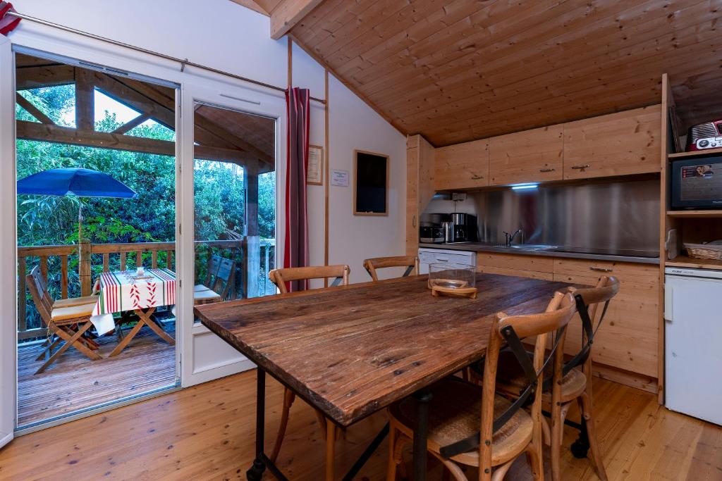 eine Küche und ein Esszimmer mit einem Holztisch in der Unterkunft Les chats perchés 400m plage D in Labenne
