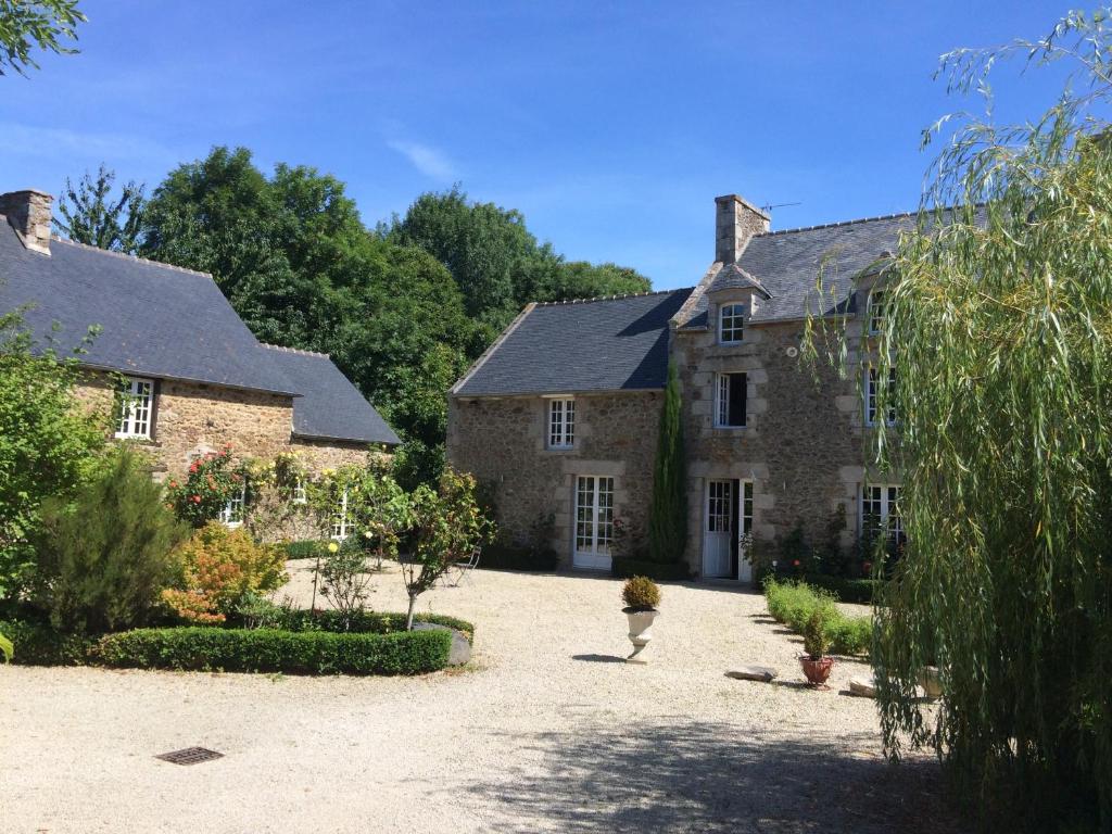 Una gran casa de piedra con un patio enfrente. en Manoir de La Rogerais & SPA, en Beaussais sur Mer