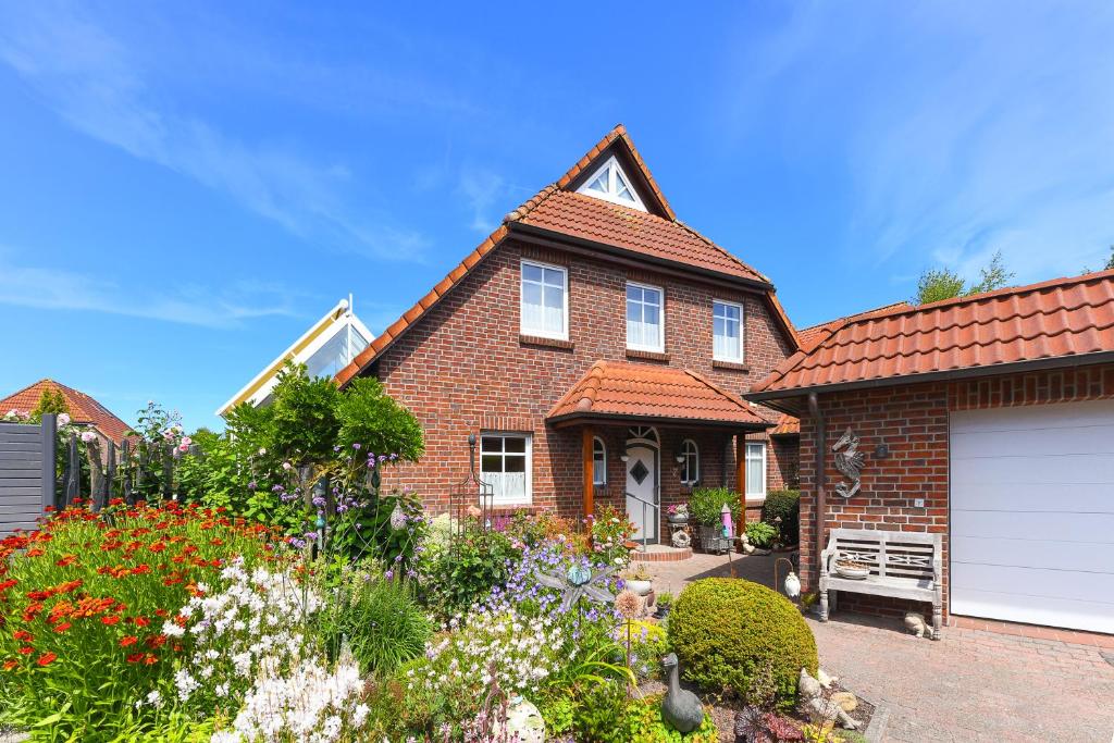 a brown brick house with a white garage at Haus Strandlooper in Neuharlingersiel