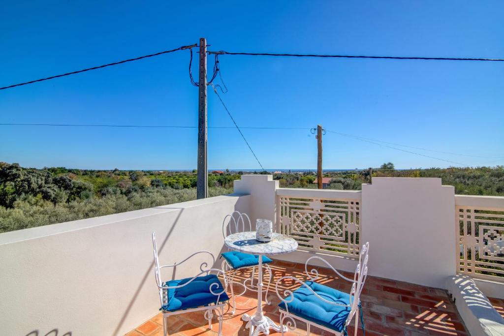 ein Balkon mit Tisch und Stühlen und Aussicht in der Unterkunft Villa Oliva Al ii in Moncarapacho