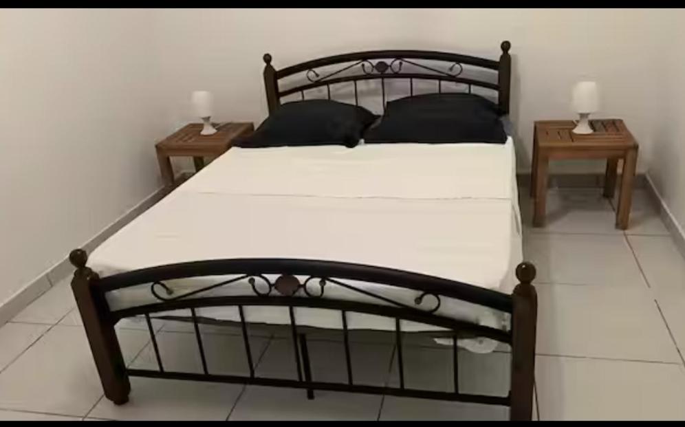 a bedroom with a black bed with two tables at Kaz'Eliz in Le Tampon