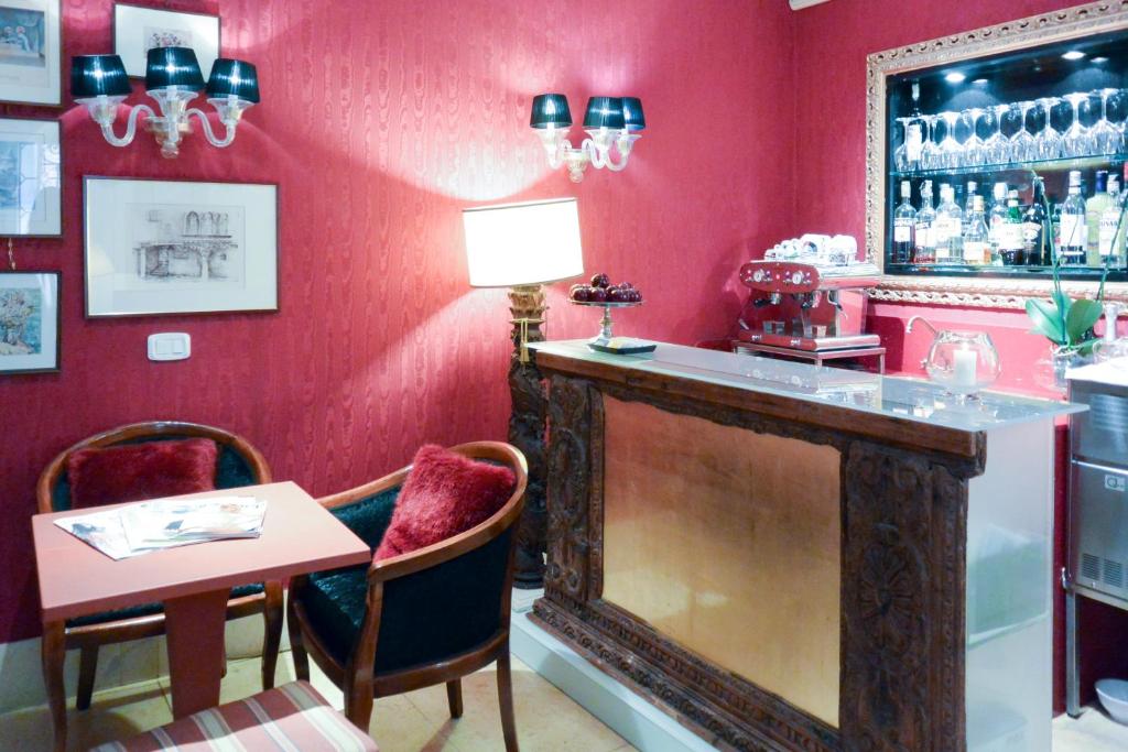 a red room with a bar with a table and chairs at Hotel Casa Verardo Residenza d'Epoca in Venice