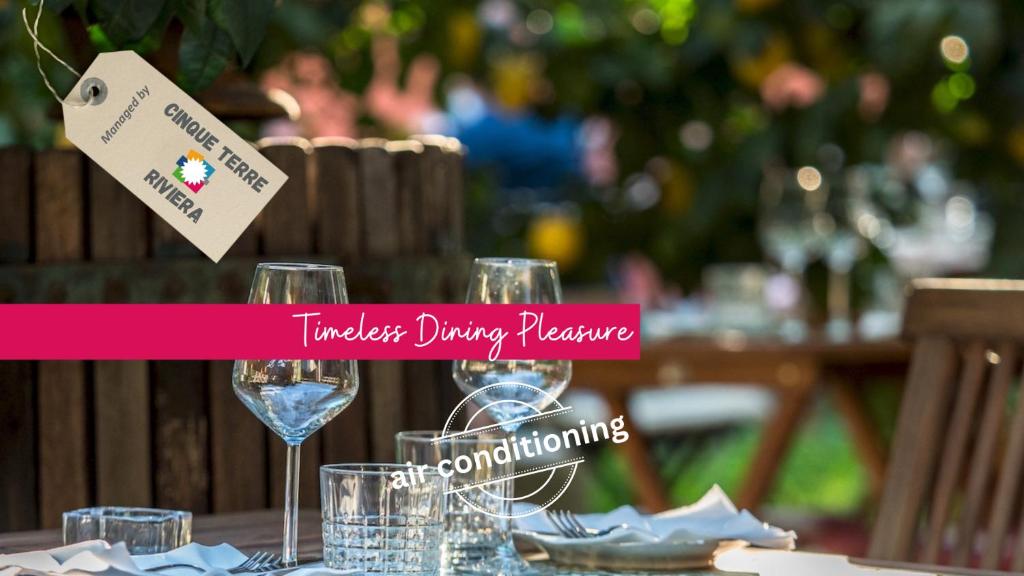 a table with wine glasses and a sign on it at Liersena Sea View Mini Villa with AC in Manarola