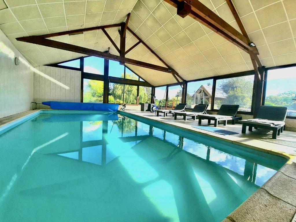 a swimming pool with blue water in a house at O'gîte Bleu pour 14 personnes in Huillé