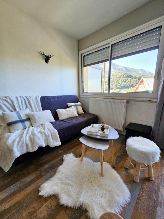 a living room with a couch and a table at Station de ski Gourette, Appartement avec chambre in Gourette