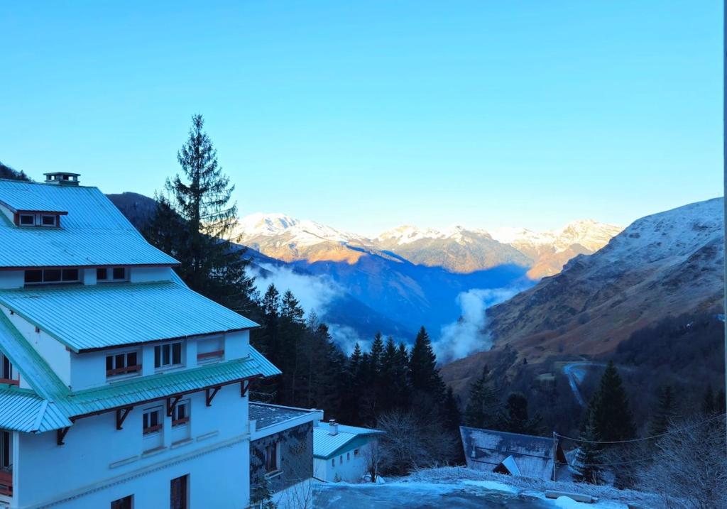 a building with snowy mountains in the background at Appartement avec chambre Gourette in Gourette