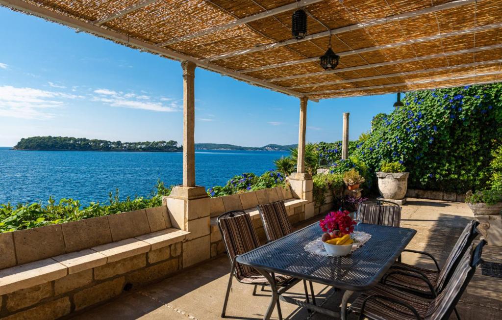 a table and chairs on a patio with a view of the water at Beach house Lozica by Villas Guide in Dubrovnik