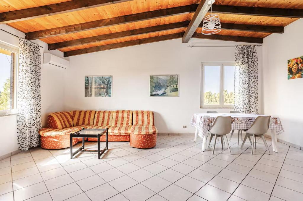 a living room with a couch and a table at Tra Mare e Campagna - Cortile privato e relax in Palmas Arborea