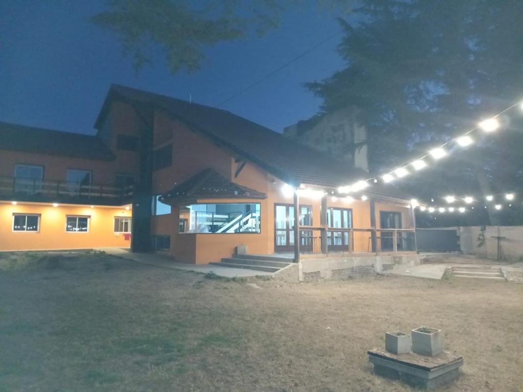 a house lit up at night with lights at Hostal Viví La Pampa in Santa Rosa