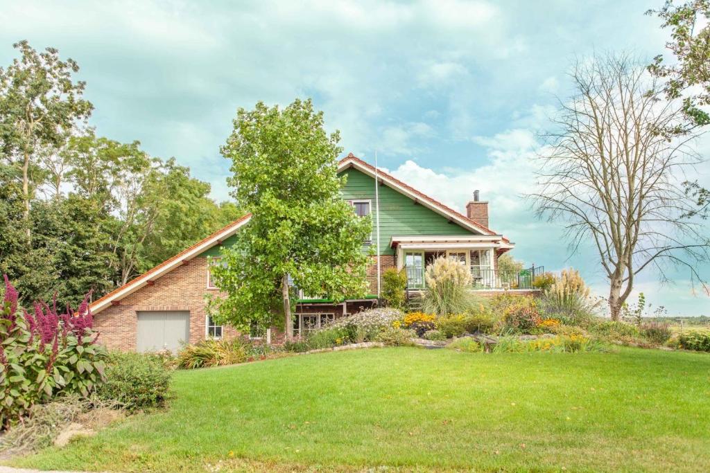a green house with a yard at Beautiful house in nature for 20 people in Wetering