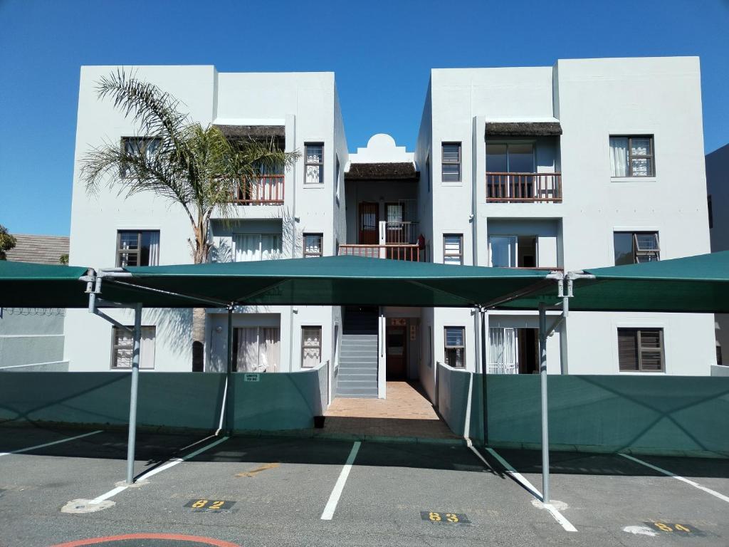 a large white building with a parking lot at Serengeti Self Catering Units in Bellville