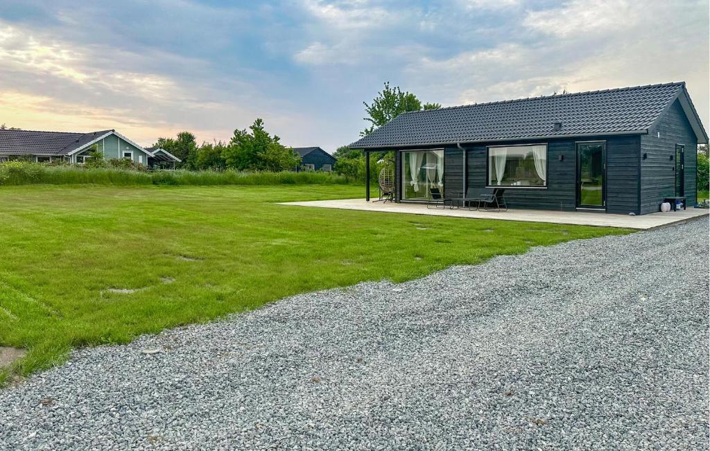 Beautiful Home In Hørve With Wifi في Hørve: منزل أسود صغير مع ساحة عشب