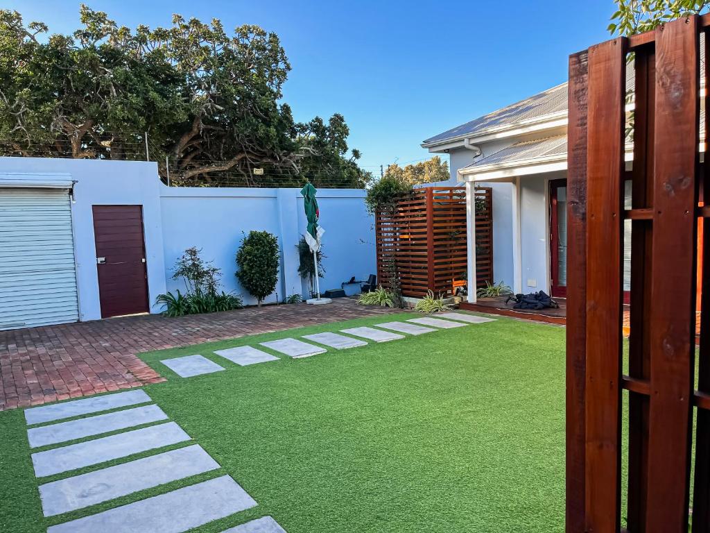 a backyard with green grass and a fence at Peaceful Home In Richmond Hill in Gqeberha