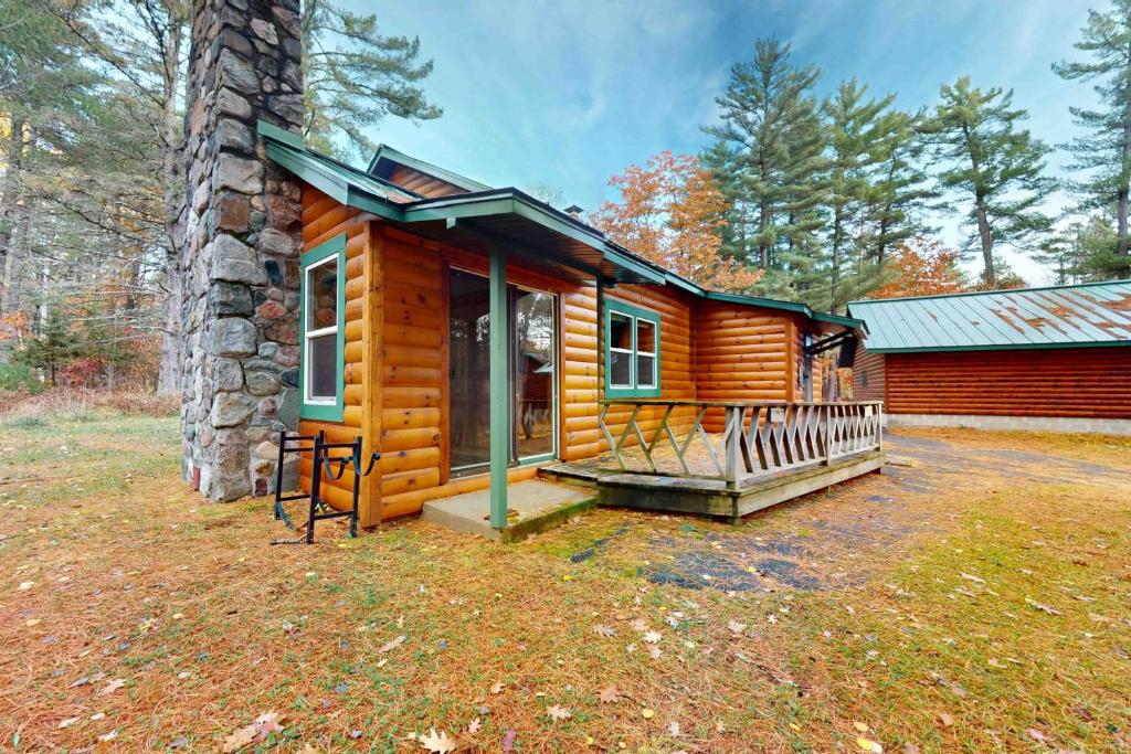 a log cabin with a porch and a building at Camp Farrell Cabin in Manitowish Waters