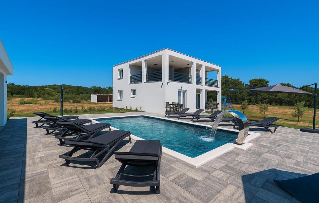 a swimming pool with lounge chairs and a house at Villa Jani by Villas Guide in Donja Jagodnja