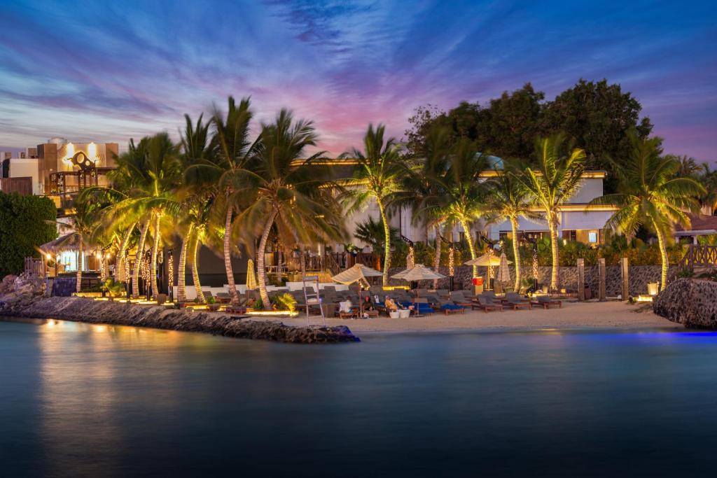 un complexe hôtelier avec des palmiers et une plage la nuit dans l'établissement Narcissus Obhur Resort & Spa, à Djeddah