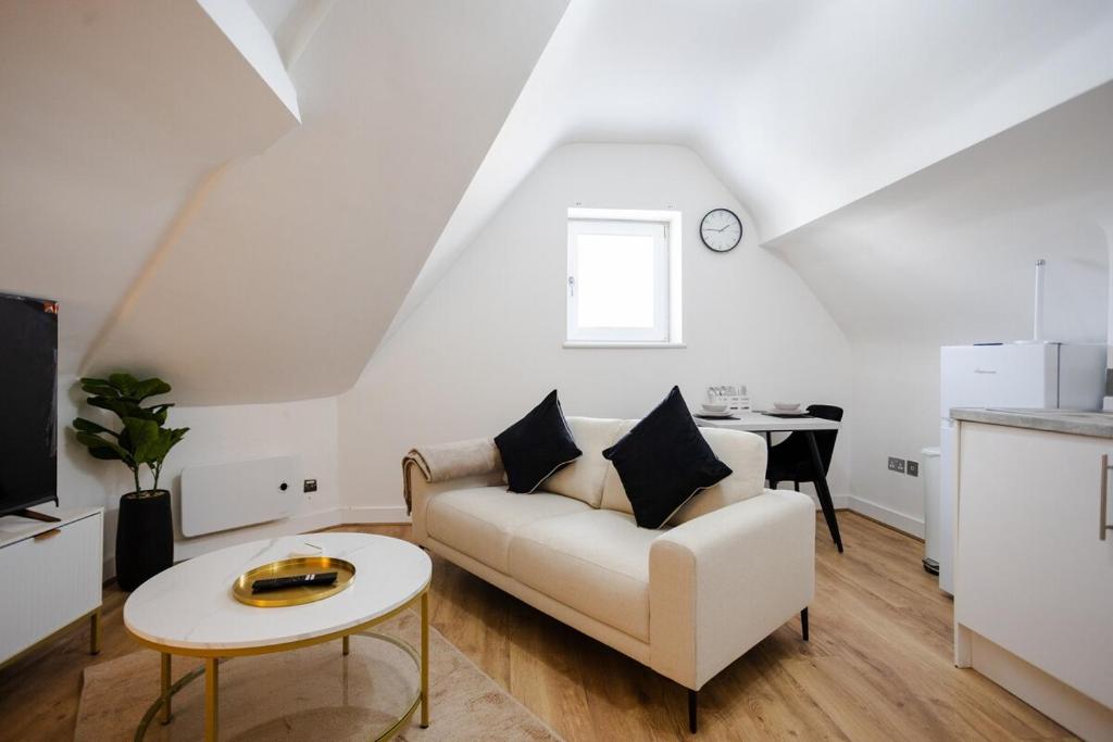 ein Wohnzimmer mit einer weißen Couch und einem Tisch in der Unterkunft Modern 1-BR Apartment near Cardiff City Centre in Cardiff