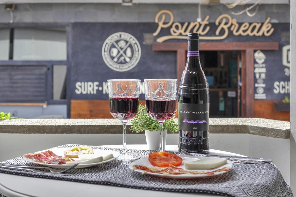 eine Flasche Wein und zwei Gläser auf einem Tisch in der Unterkunft 7even in Corralejo