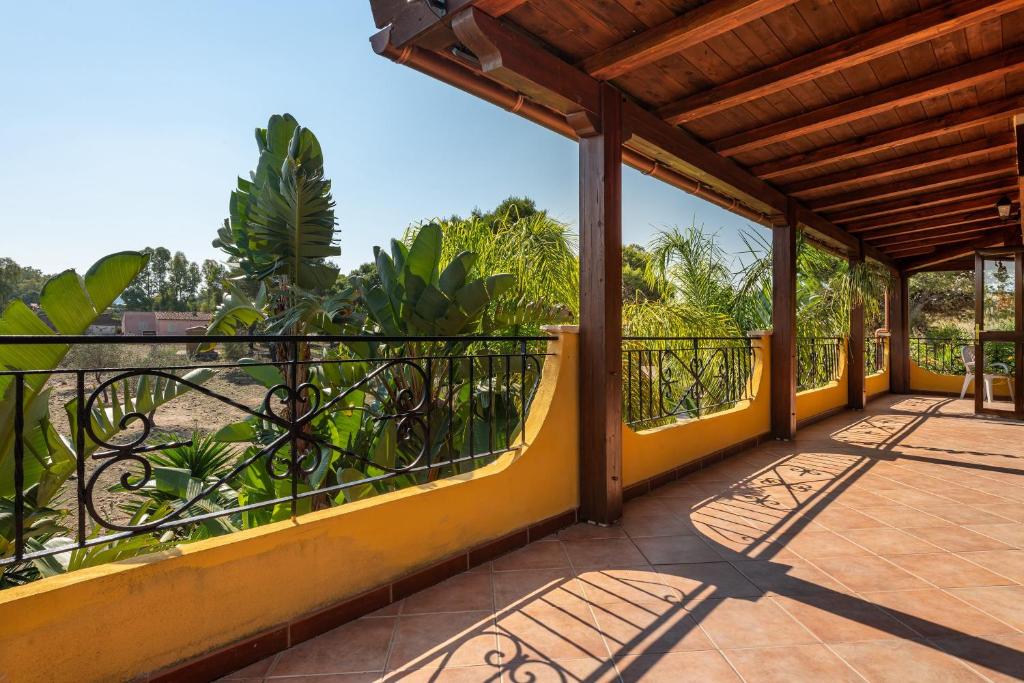 a balcony of a house with yellow walls and trees at Villa Mallus 5 posti letto in Olìa Speciosa