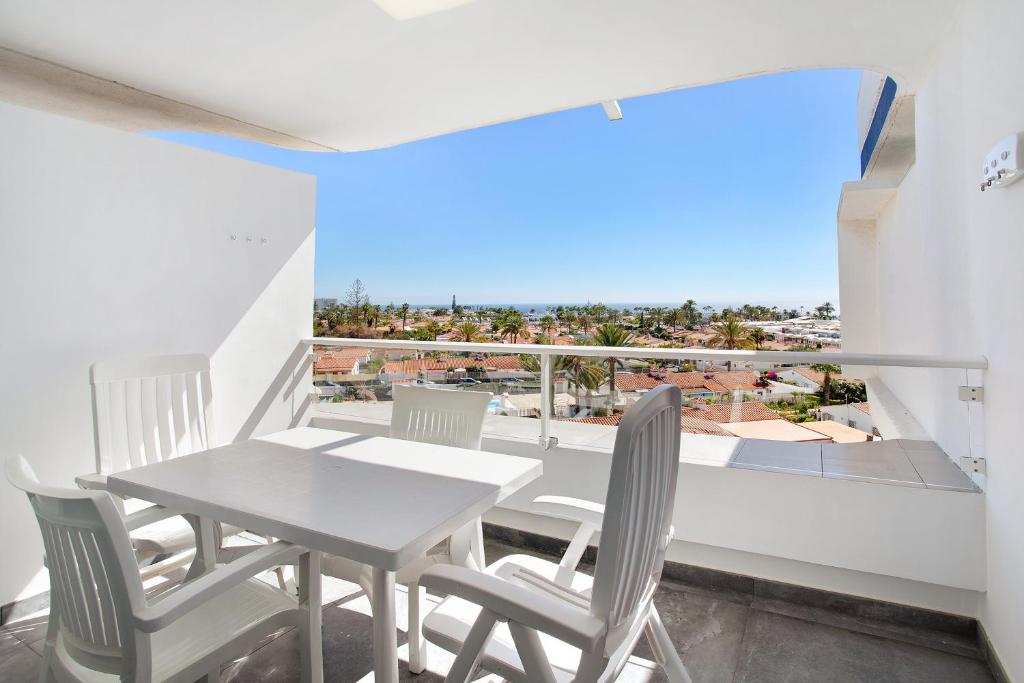 a table and chairs on a balcony with a view of the ocean at Tamaran Bureba 511 in Maspalomas