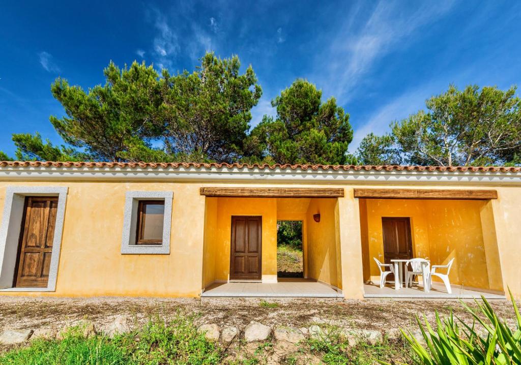 an orange house with two doors and a patio at ISA - Apartments with common swimming-pool and outdoor private area in Badesi in Badesi