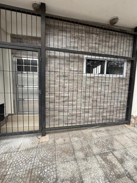 a metal gate in a building with two windows at Departamento Rojas 1 in San Fernando del Valle de Catamarca