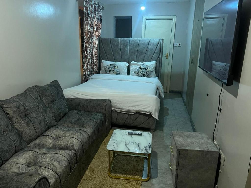 a living room with a couch and a bed at Home sweet home in Nairobi