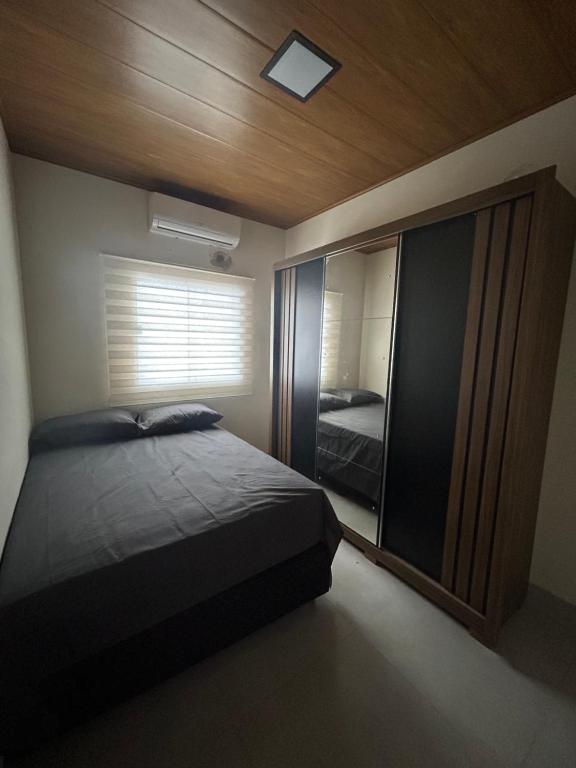 a bedroom with a bed and a large window at Espaço completo com garagem, estrutura e móveis novos! in Rondonópolis