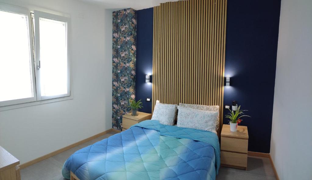 une chambre avec un lit bleu et une fenêtre dans l'établissement Cà Maurizio garden Venezia, à Marghera