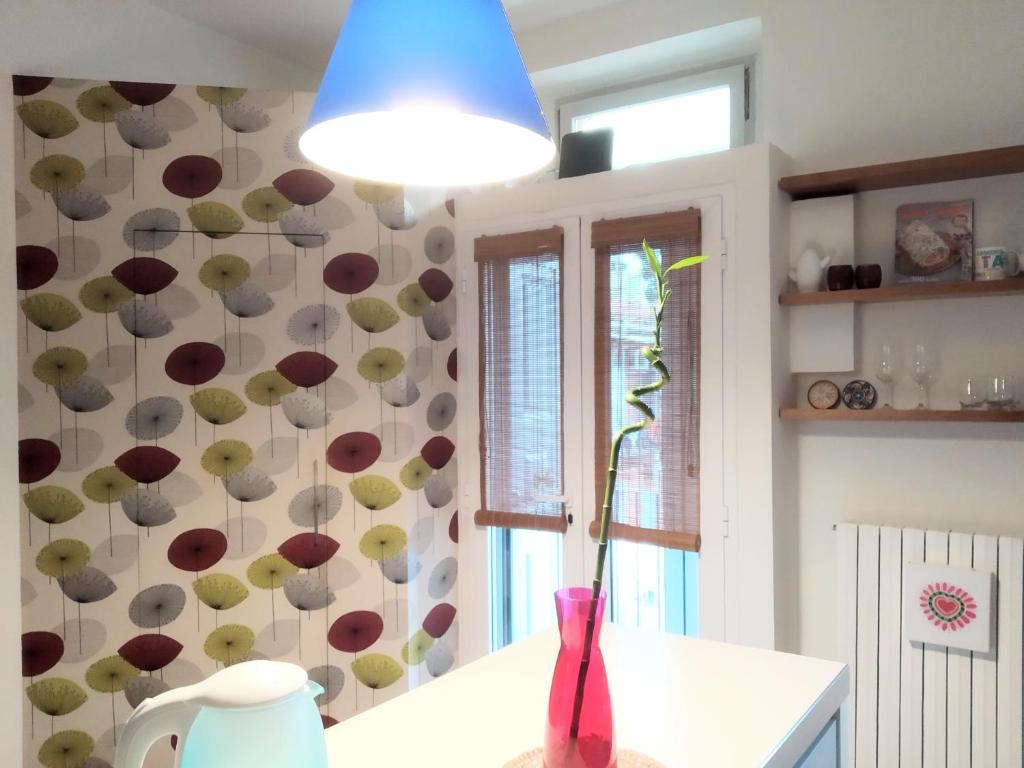 a vase on a table in a kitchen with a wall at Isola Blu Milano in Milan