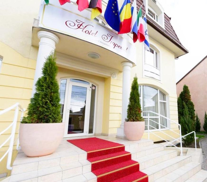 ティミショアラにあるHotel Imperial Timisoara by JRの建物の前に赤い絨毯が敷かれたホテル