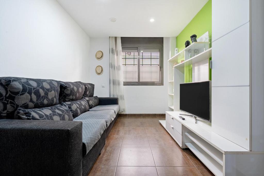 a living room with a couch and a flat screen tv at Vendrell Centre in El Vendrell